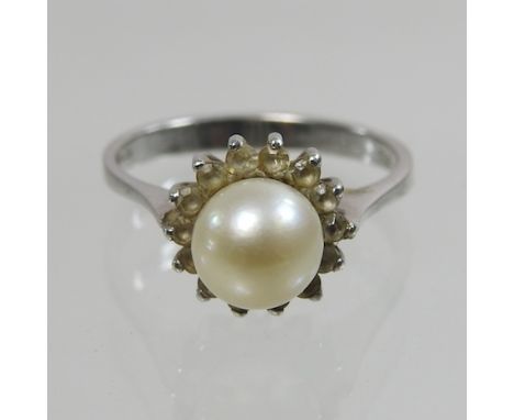 An 18 carat white gold diamond and pearl ring, boxed