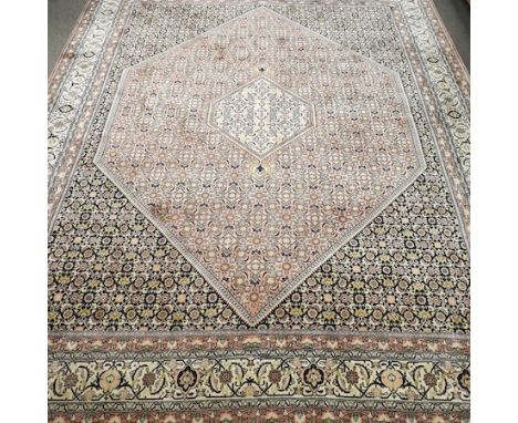 A Persian woollen carpet, on a pink ground, 320 x 250cm