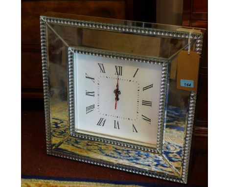 A contemporary clock with mirrored border, having bevelled plates 