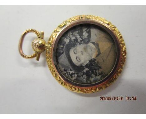 A late Victorian/Edwardian yellow metal pendant, with photographs to the front and reverse, on a suspension ring 