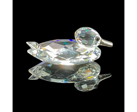 The crystal mini duck is crafted from clear, faceted crystal, featuring black eyes and a silver-colored metal bill (beak). Sw