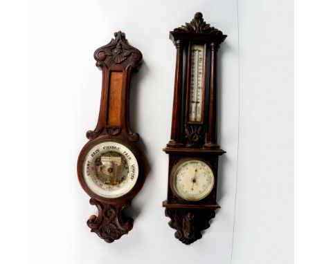 Two barometers housed in carved wood frames. One has a thermometer in the lower section, 28.5"H x 7.75"W x 2.25"D. The other 