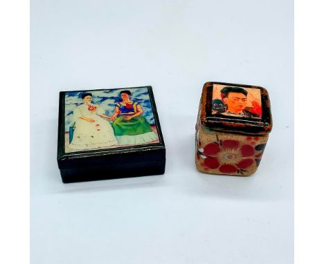A collection of miniature boxes decorated with the photos of Frida Kahlo's self-portraits. One box is black resin featuring L