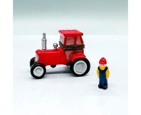 A painted box molded as a red tractor. Includes a tiny farmer inside. Dimensions: 3"L x 1.75"W x 2"HCondition: Age related we