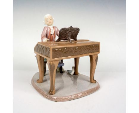 This glossy porcelain figurine depicts a young Mozart on the clavichord. Lladro backstamp. This item has its original box whi