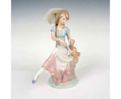 Porcelain Figurine of young girl sitting with her dog and a parasol in hand. Lladro backstamp. This item has its original box