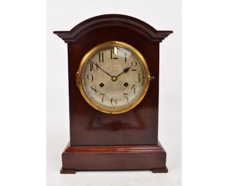 An Edwardian mahogany domed bracket clock, the circular silvered dial set with Arabic numerals, and pediment base on bracket 