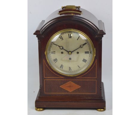 A large Edwardian mahogany inlaid and brass detailed eight day mantel clock, the domed hood with central carrying handle abov