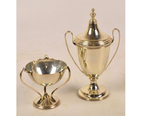 A George V hallmarked silver urn with tapering cover and cast finial, with twin high loop handles, raised on spreading and st