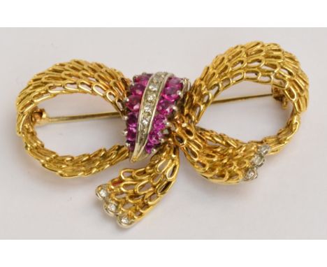 An 18ct yellow gold and white gold tipped diamond and ruby set bow brooch of pierced form with central band of graduated diam