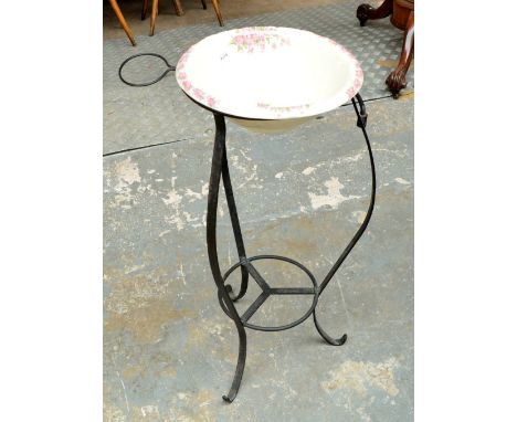 A reproduction wrought iron and ceramic wash stand with a large circular bowl and smaller attached soap dish, height 85cm.