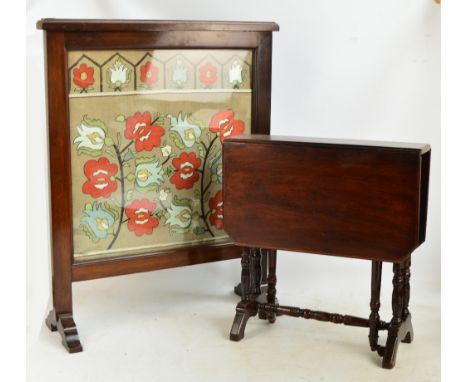 A late 19th/early 20th century mahogany fire screen with embroidered panel decorated with stylised flowers behind glass, heig