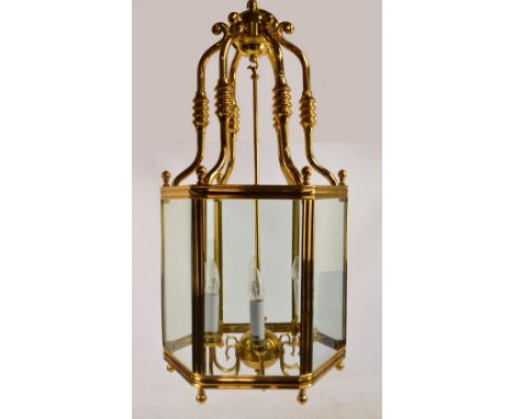 A small hexagonal brass lantern with bevelled plain glass panels and bevelled curved shaped top pieces with pierced frieze an