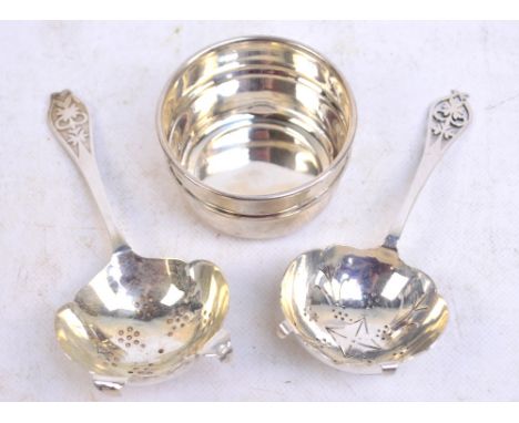 An Elizabeth II hallmarked silver tea strainer with finial decorated with a floral motif, and another example with the same m