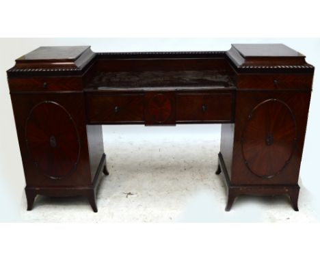 An Edwardian mahogany drop centre sideboard with twin pedestals set with a drawer above cupboard doors centred with a further