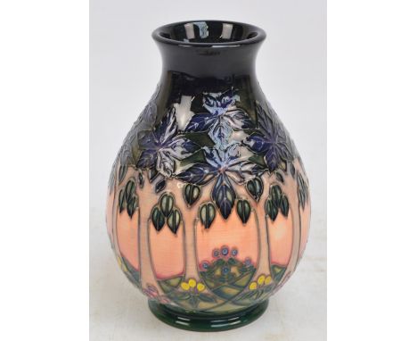 A William John Moorcroft of baluster form tube line decorated with continuous landscape with trees and flowers, on dark blue 