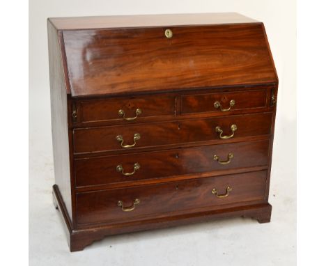 A George III mahogany bureau with fall front enclosing fitted interior above two short and three long drawers on plinth base 
