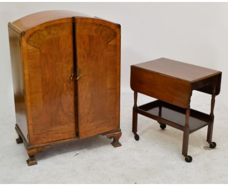 A 1940s walnut cabinet with domed top and pair of doors enclosing a shelf above three long frieze drawers, to square tapering