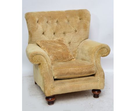 A modern armchair with button back, outswept arms in a cream lozenge pattern fabric with bulbous feet, with matching cushion.