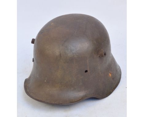 A WWI German tin helmet, stamped "E.T. 64" (lacking interior).