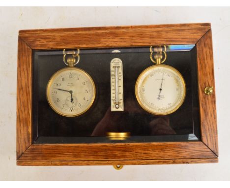 An early 20th century oak cased glazed display cabinet containing a Ross of London matching eight day travelling clock with s