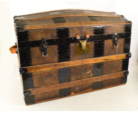 A wooden domed blanket box or travelling trunk with studded metal strapping and further wooden bands with metal clasps and le