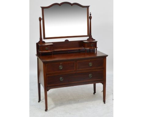 An Edwardian mahogany and inlaid dressing chest with shaped swing bevelled mirror above shelf flanked by two drawers, with tw