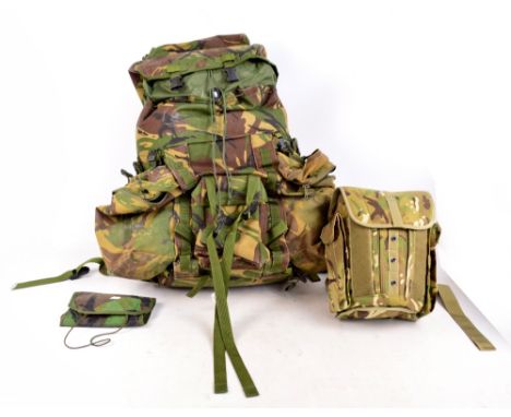 An Army camouflage rucksack with kit bag inside, a field pack in camouflage case containing a gas mask, and a camouflage roll