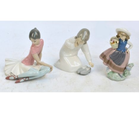 Three Lladro figures; a seated ballet dancer, a girl with basket of flowers and a girl kneeling beside a pair of shoes (3).