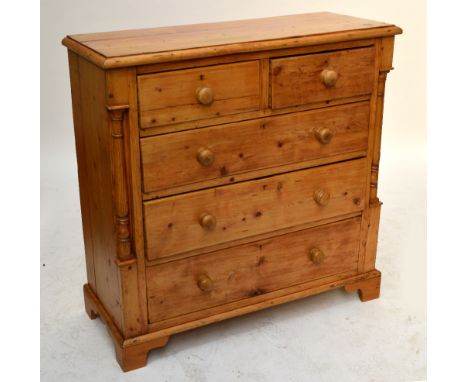 A Victorian pine chest of two short above three long drawers flanked by turned pillars, with plinth base on ogee bracket feet