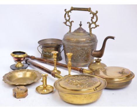 A group of brassware to include a large kettle with incised decoration, two warming pans, a chamber stick and a bottle coaste