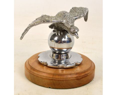 A Desmo car mascot modelled as an eagle upon a spear with radiator screw cap cover attached, and mounted on a wooden plinth, 