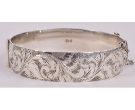 An Elizabeth II hallmarked silver hinged snap bangle with foliate engraved decoration, London 1975, width approx 6.5cm.