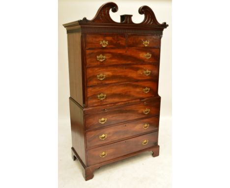 A George III mahogany chest on chest, the carved broken swan neck pediment above dentil moulded cornice and two short and thr