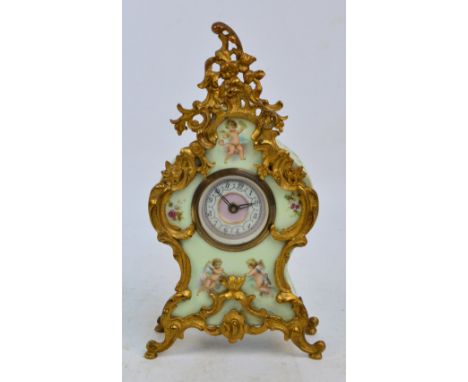 A late 19th/early 20th century French porcelain mantel timepiece decorated with putti and with gilt metal mounts and feet, th