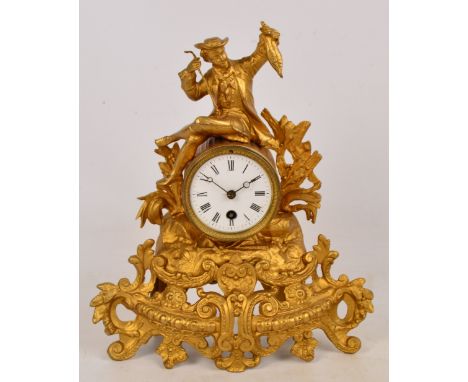 A late 19th century French gilt spelter figural mantel clock with white enamel dial set with Roman numerals and scrolling fol