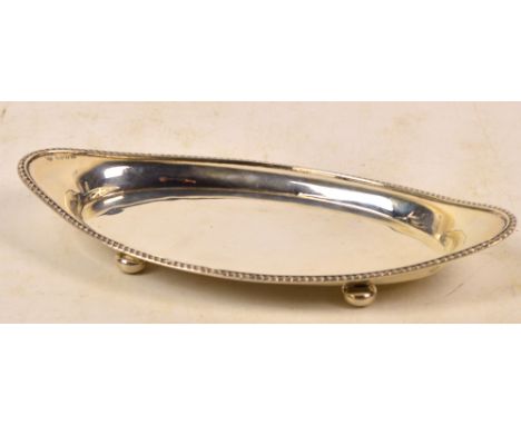 An Edward VII hallmarked silver navette shaped dish with rope twist decorated rim, raised on four bun feet, Haseler Bros, Che