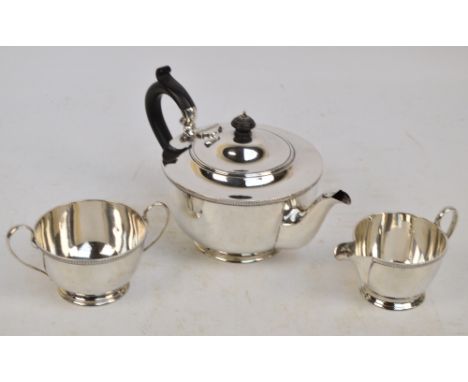 An Elizabeth II hallmarked silver three piece tea set of plain circular form with ribbed rim, Harrison Bros & Howson, Sheffie