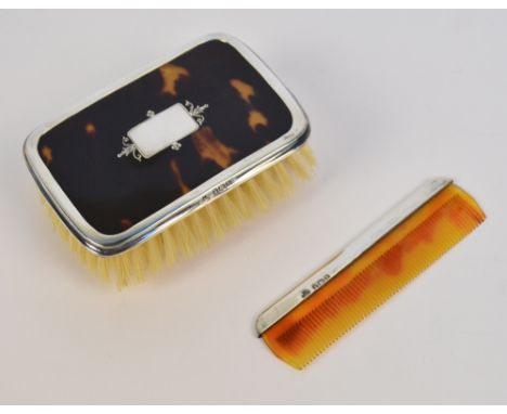 A cased George V hallmarked silver mounted and tortoiseshell baby brush of rounded rectangular form, centred with inlaid vaca