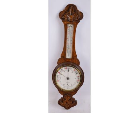 A 1920s carved oak banjo aneroid barometer/thermometer by Griffith Owen and Son, height 85cm.