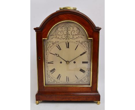 A Regency mahogany and brass detailed bracket clock, the swing loop handle above arched silvered dial set with Roman numerals