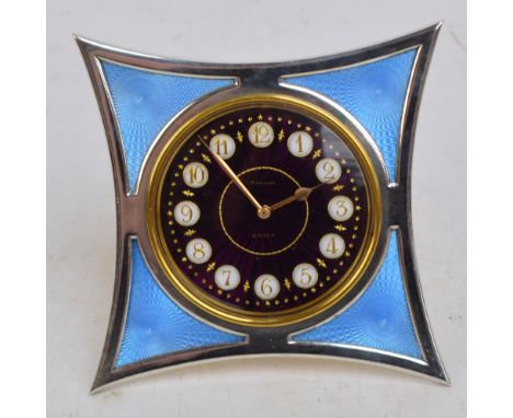 An unusual French hallmarked silver and enamel decorated easel backed timepiece, the purple enamelled dial set with gilded Ar