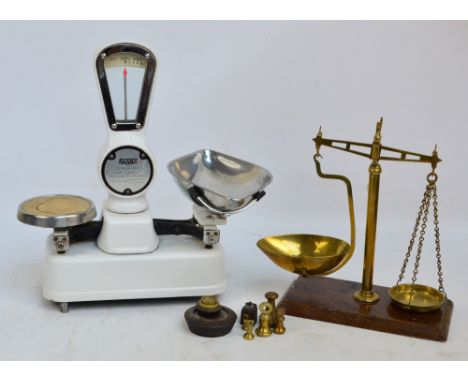 A set of brass beam scales set on a wooden plinth, inscribed "Class B to Weight 8ozs", one pan inscribed "Wood Green C.Pollar