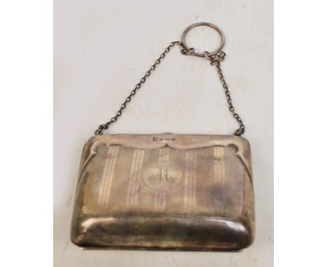 A George V hallmarked silver purse in the form of a bag suspended on silver ring loop and silver chains, decorated with linea