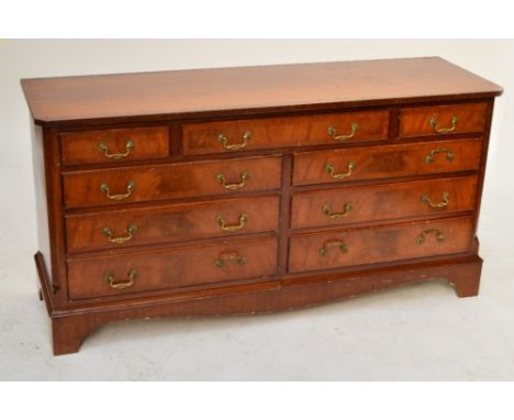 A reproduction mahogany crossbanded sideboard with an arrangement of drawers on bracket feet, width 153cm.