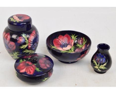 Four pieces of modern Moorcroft in the "Anemone" pattern on a rich blue ground, comprising a bowl, a lidded bowl, a small bal