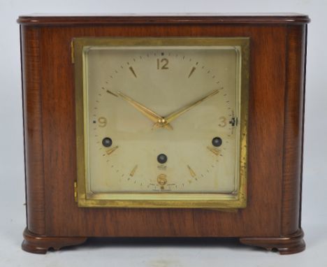 An Art Deco style walnut Elliot mantel clock with square section dial set with Arabic numerals and gold batons with French es