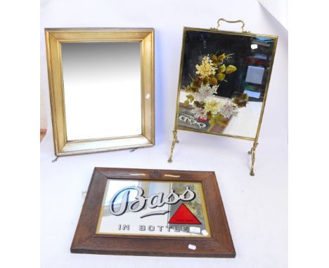 A mirrored brass mounted floral hand painted fire screen, height 71cm including handle, a "Bass in Bottle" advertising mirror