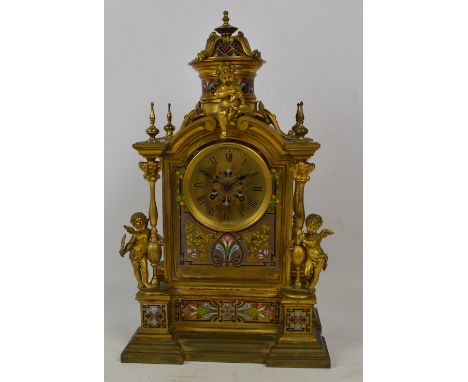 A French 19th century gilt metal and champlevé enamel decorated mantel clock, the circular dial set with Roman numerals, hous