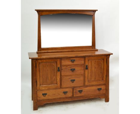 An oak sideboard with three short central drawers flanked by two hinged doors, each enclosing a shelf above two further drawe